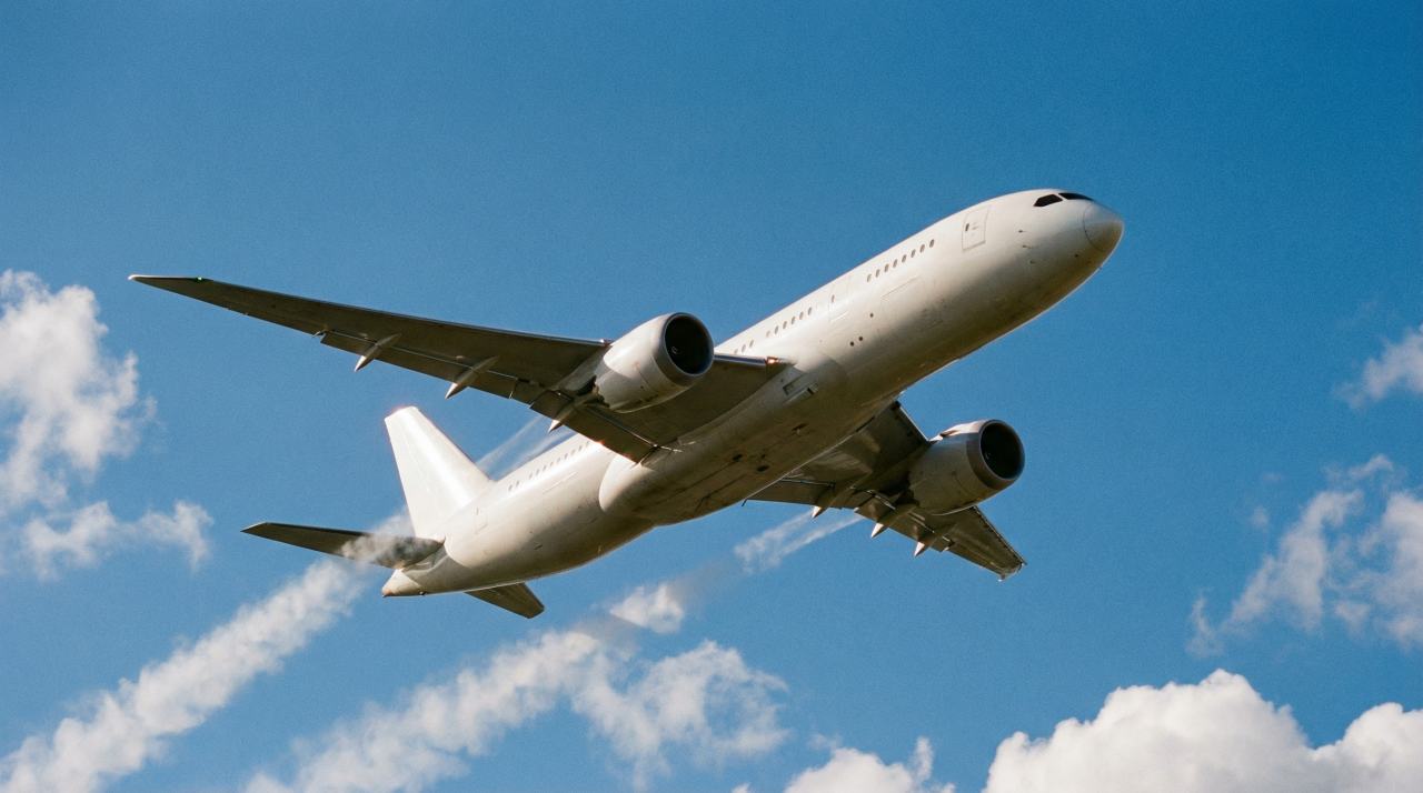 Avión de pasajeros volando en el cielo azul con algunas nubes